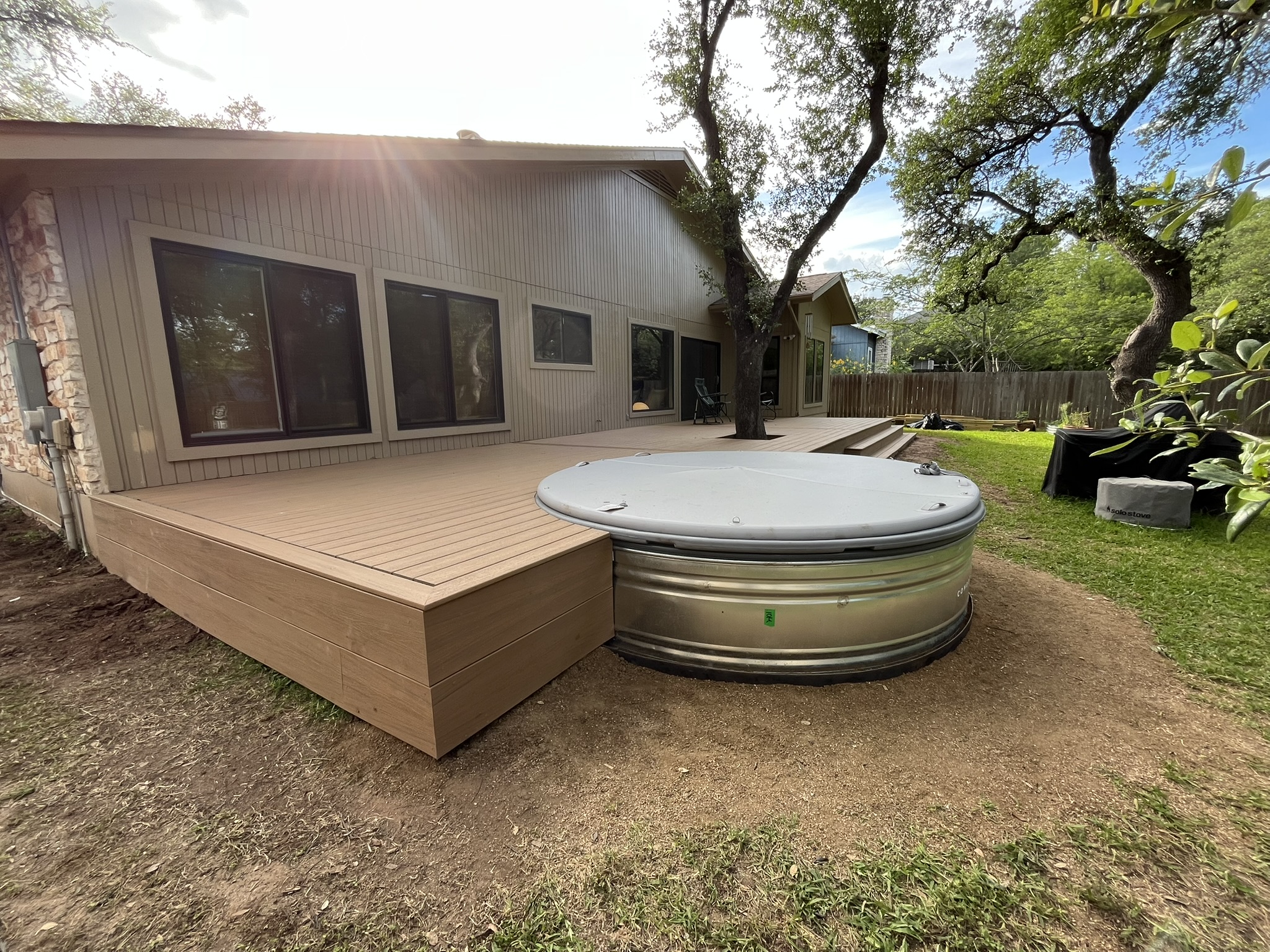 Custom composite deck wrapped around a cowboy pool in an Austin backyard